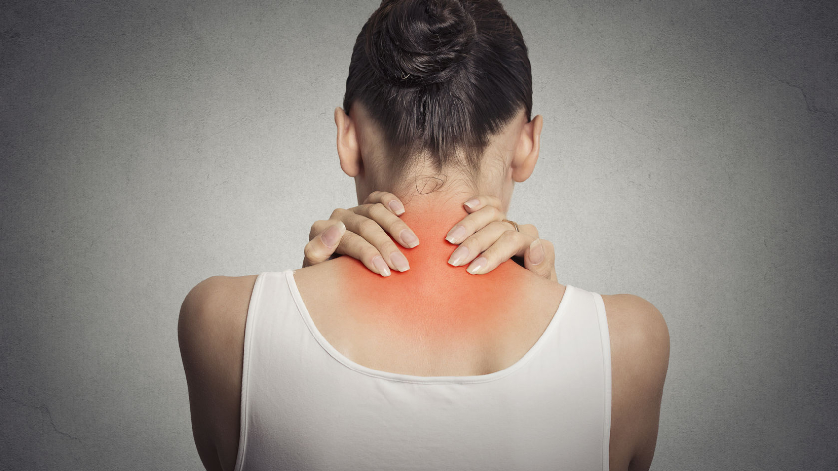 Healthy lifestyle. Back and spine disease. Closeup back view tired female massaging her neck colored in red isolated on gray background
