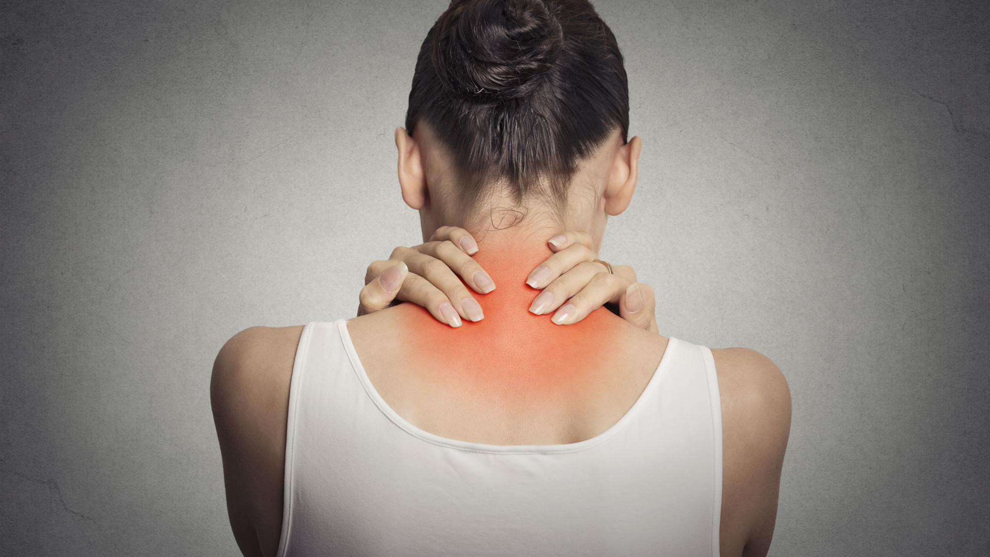 Healthy lifestyle. Back and spine disease. Closeup back view tired female massaging her neck colored in red isolated on gray background